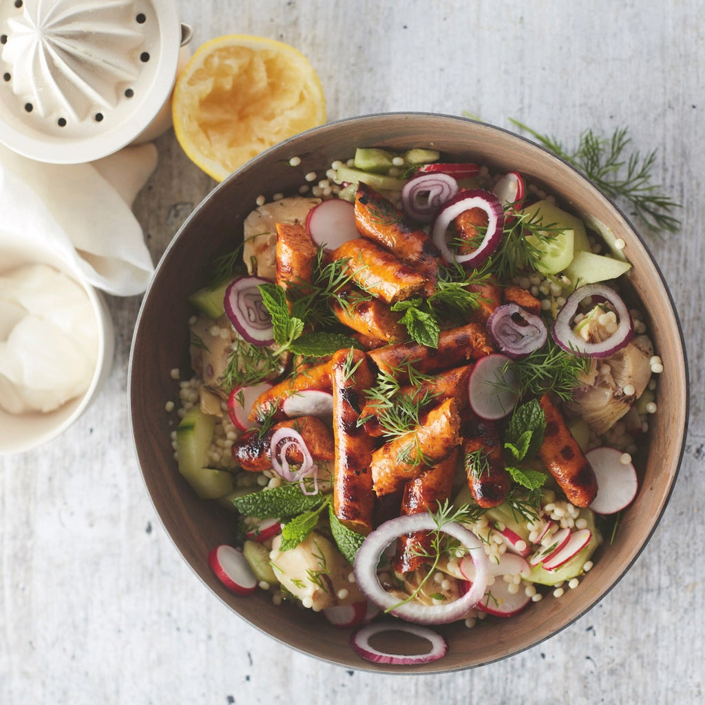 Gegrilde merguez-worst met parelcouscous, artisjok en komkommer